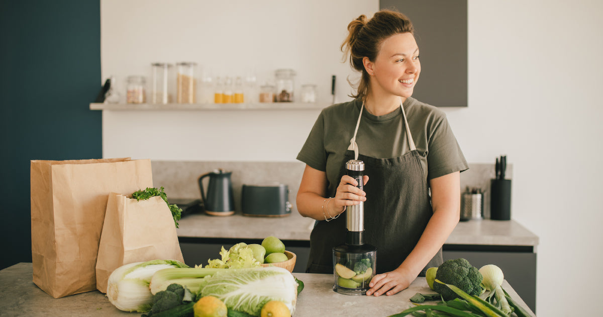 Woman in kitchen, making a smoothie